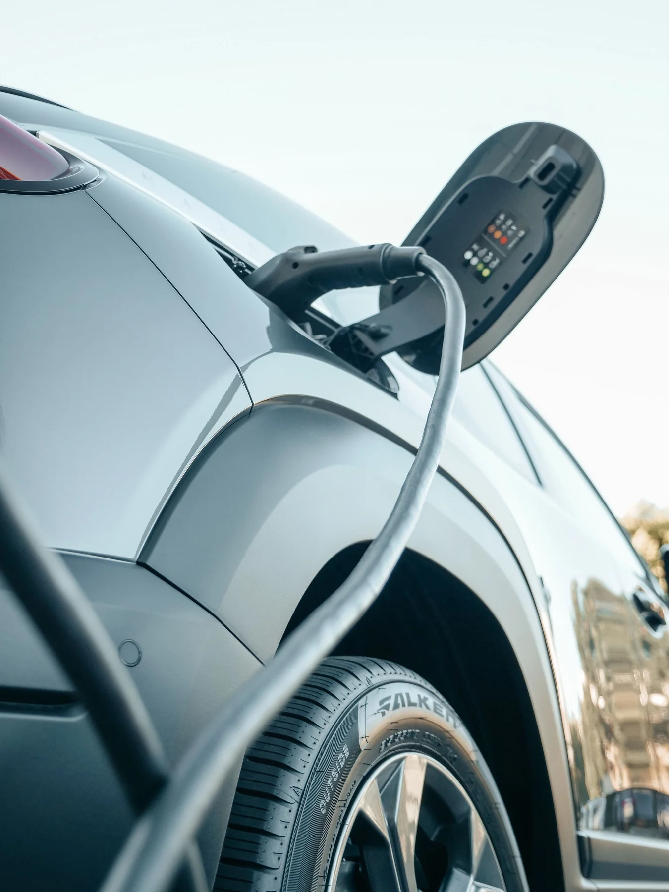 An electric vehicle connected to a charging plug.