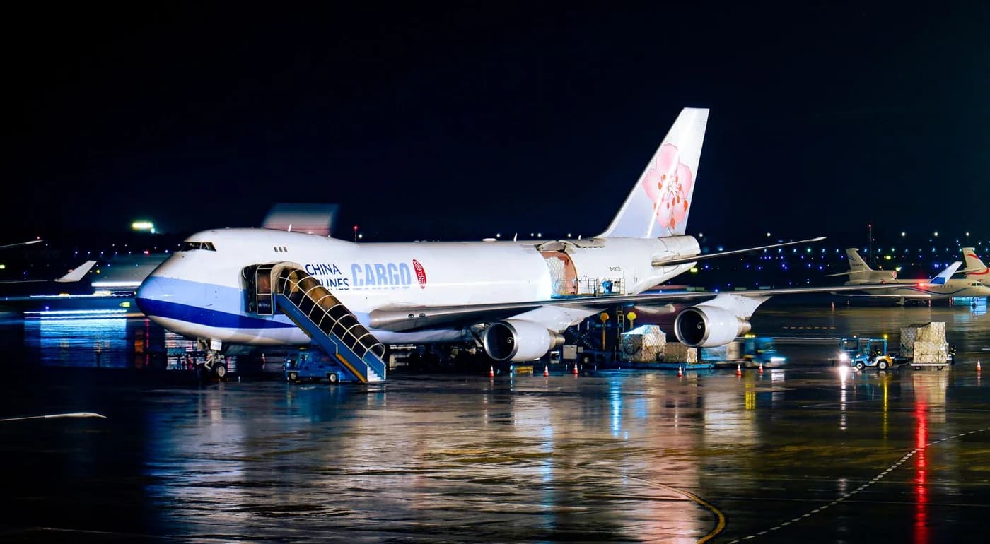 Cargo aircraft on an airport apron at night.